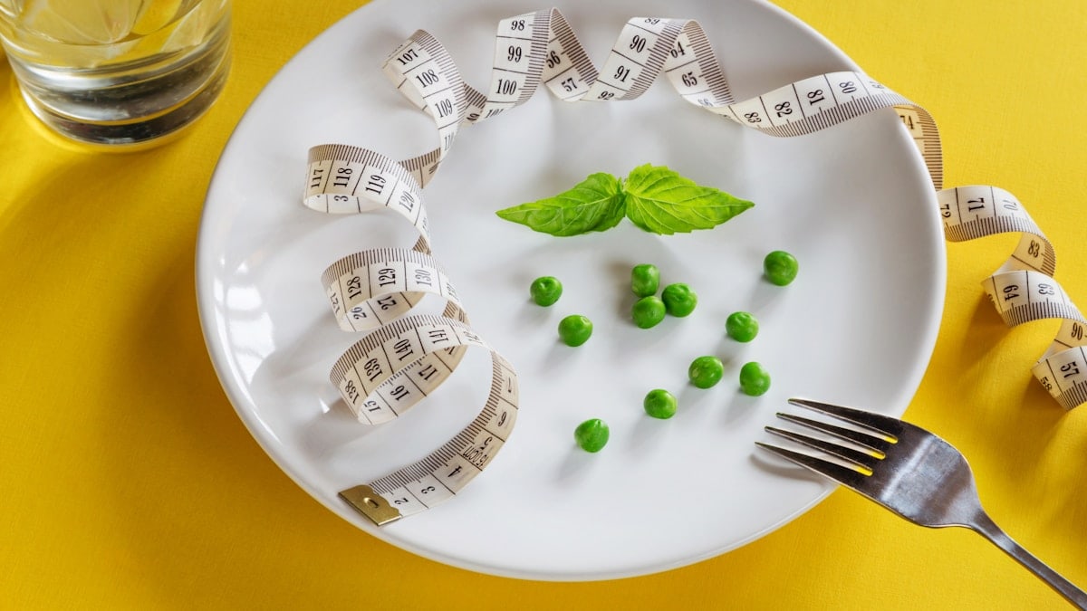 Diet white plate with centimeter peas and basil